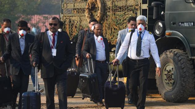 Crew members and officials of an Indian airline carry their belongings while wearing protective masks as a precaution against a possible coronavirus infection on their return from China, at Indira Gandhi International Airport, in New Delhi. (Amal KS/HT PHOTO) Crew members and officials of an Indian airline carry their belongings while wearing protective masks as a precaution against a possible coronavirus infection on their return from China, at Indira Gandhi International Airport, in New Delhi. (Amal KS/HT PHOTO)