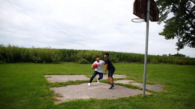 Angel Lucatero and Miguel Almanza play basketball near a cornfield in West Liberty. (Eric Thayer / REUTERS)
