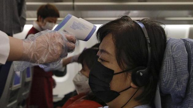 Stewardesses take temperatures of passengers as a preventive measure for the coronavirus on an Air China flight from Melbourne to Beijing before it land at Beijing Capital International Airport in China. (AP) Stewardesses take temperatures of passengers as a preventive measure for the coronavirus on an Air China flight from Melbourne to Beijing before it land at Beijing Capital International Airport in China. (AP)