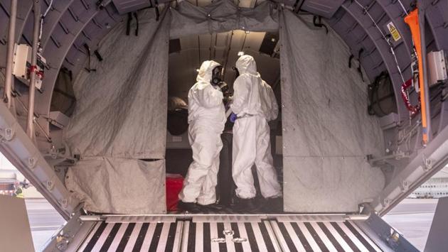 Polish military personnel wearing protective suits stand on board a military aircraft used to transport evacuees from Wuhan. South Korea, which has 15 confirmed cases, was quarantining 800 soldiers who had recently visited China, Hong Kong or Macao or had contact with people who had, defense ministry spokeswoman Choi Hyunsoo said. (Arek Rataj / AP)