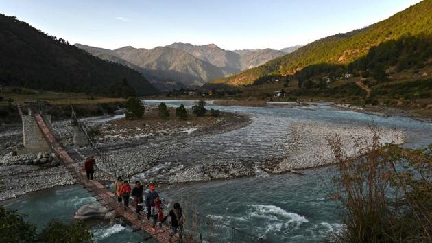 This photo taken on December 6, 2019 shows tourists walking on a suspension bridge over the Puna Tsang Chhu river in Punakha province in Bhutan. (AFP) This photo taken on December 6, 2019 shows tourists walking on a suspension bridge over the Puna Tsang Chhu river in Punakha province in Bhutan. (AFP)