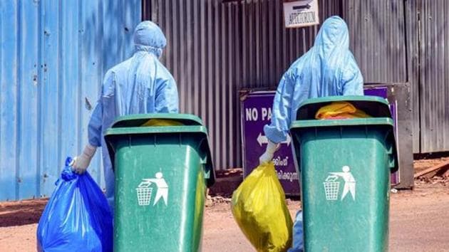Medical staff, wearing protective suits, hold medical waste as they leave the special isolation ward set up to provide treatment to coronavirus patients, Kochi Medical College, Kerala, February 4, 2020(PTI)
