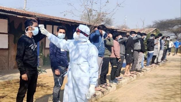 Haryana, Feb 03 (ANI): A medical staff scans the temperature of Indian National who arrived from coronavirus-hit Wuhan, put for medical observation, at quarantine center, in Manesar on Monday. (ANI Photo)