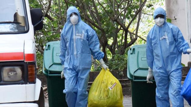 Medical staff in protective suits disposing of waste as they exit from a coronavirus isolation ward at Kochi Medical collage in Kerala on Tuesday. (ANI) Medical staff in protective suits disposing of waste as they exit from a coronavirus isolation ward at Kochi Medical collage in Kerala on Tuesday. (ANI)