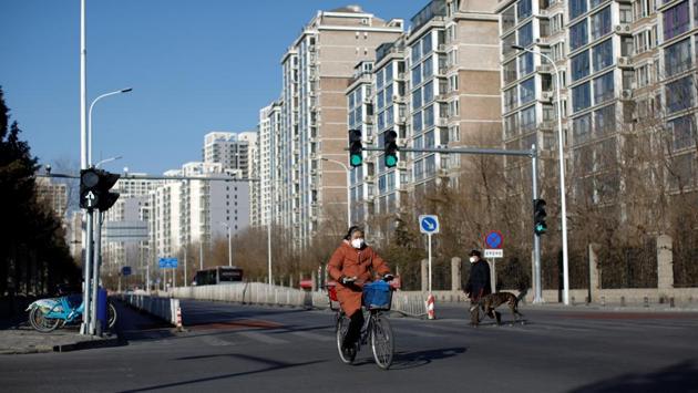 A woman wearing a face mask rides a bicycle as the country is hit by an outbreak of the new coronavirus, in Beijing. Reuters reports that health officials in the United States and China have set ambitious goals for getting a vaccine to initial human testing within the next few months, although drugmakers cautioned that they have a long way to go. (Carlos Garcia Rawlins / REUTERS)