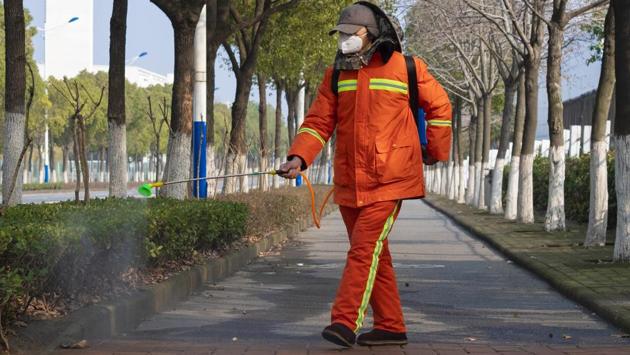 A worker wearing a face mask sprays disinfectant along a path in Wuhan. While they were relatively safe sheltering at home, treating their foyer as a type of airlock, Arek felt compelled to go out and document the outbreak of the new type of coronavirus. Among his subjects: the construction of a new hospital built in a handful of days, biosecurity check points, closed bus stations, empty streets and families gathered at playgrounds when the sun broke through winter clouds. (Arek Rataj / AP)