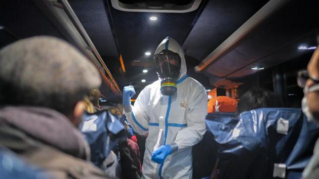A military officer wearing a protective suit gives instructions to evacuees from Wuhan. “It was like a dream ... life-changing,” Jenina said. So far, they remain healthy and Poland is free of the virus. (Arek Rataj / AP)