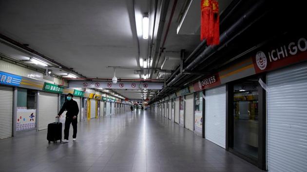 A man wearing a mask walks through closed stores in Shanghai. Small and medium-sized enterprises (SMEs), already struggling for access to credit, are bearing the brunt of the pain. That’s posing a further threat to China’s economy, growing as it is at its slowest in three decades. (Aly Song / REUTERS)