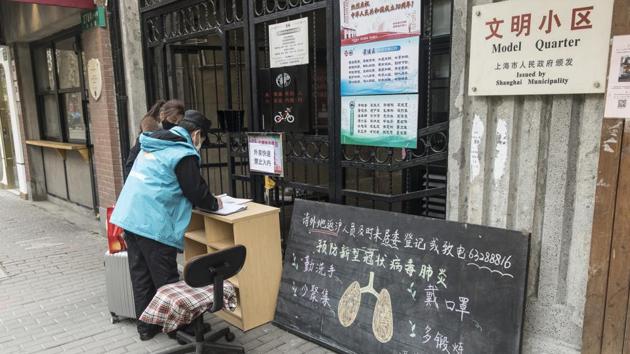 A local resident returning from travel registers with an official at the entry gate of a residential neighborhood in Shanghai, China, on Wednesday, Feb. 5, 2020.(Bloomberg) A local resident returning from travel registers with an official at the entry gate of a residential neighborhood in Shanghai, China, on Wednesday, Feb. 5, 2020.(Bloomberg)