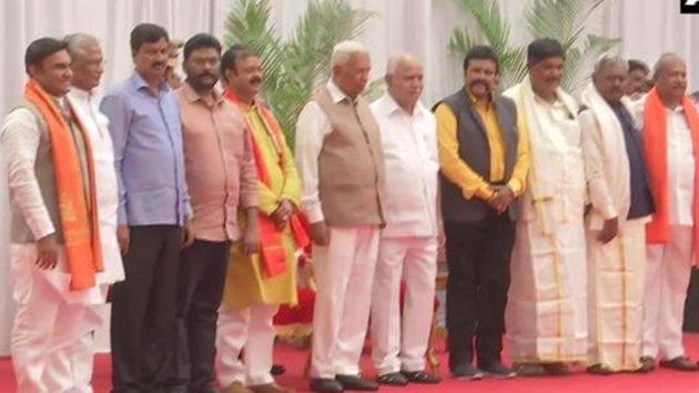 Disqualified Congress-JDS MLAs who had shifted loyalty to the BJP and won the December by-elections, were sworn-in at a simple ceremony at Raj Bhavan. (ANI Photo) Disqualified Congress-JDS MLAs who had shifted loyalty to the BJP and won the December by-elections, were sworn-in at a simple ceremony at Raj Bhavan. (ANI Photo)