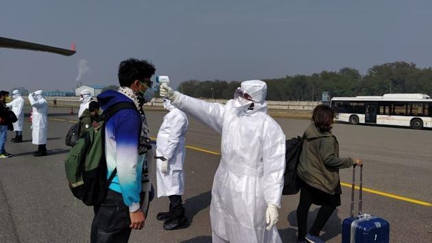 Medical officials screening passengers for coronavirus who de-boarded from the Air India special flight after landing at Indira Gandhi International Airport, in New Delhi on Sunday.(ITBP/HT Photo)