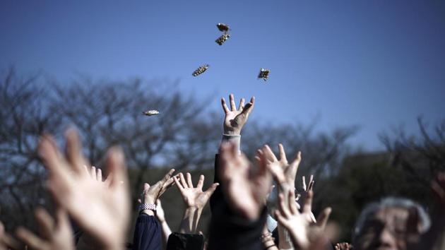 People try to catch lucky beans scattered by celebrities during “Mame-maki,” a bean throwing ceremony, at Zojoji Buddhist temple in Tokyo. The ritual, performed annually to mark the beginning of the spring in the lunar calendar, is believed to bring good luck and drive away evil. (Eugene Hoshiko / AP)