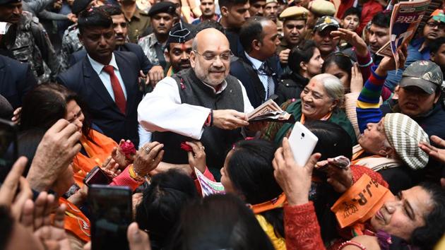 Petals are showered on Home Minister and former Bharatiya Janata Party (BJP) president Amit Shah as he greets locals during a door-to-door campaign under ‘Maha Jan Sampark Abhiyan’ ahead of Delhi Vidhan Sabha elections, at Old Mehram Nagar. (Vipin Kumar / HT Photo)