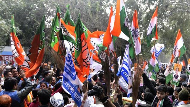 AAP, Congress and BJP supporters wave flags and shout slogans outside (RO Office) SDM in New Delhi. Delhi police will use drones and social media monitoring for the polling day vigil. They have already started motorcycle and foot patrolling in sensitive areas, whereas paramilitary forces have been deployed in sensitive booths across the city. Results will out on Tuesday. (Sonu Mehta / HT Photo)