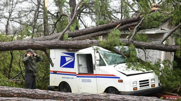 A man talks on the phone next to a damaged postal truck at an apartment complex where a reported tornado passed through, in Spartanburg. A powerful winter storm brought severe weather across the Deep South early Thursday, with high winds causing damage that killed one person, injured several others and littered at least four states. (Sean Rayford / AP)