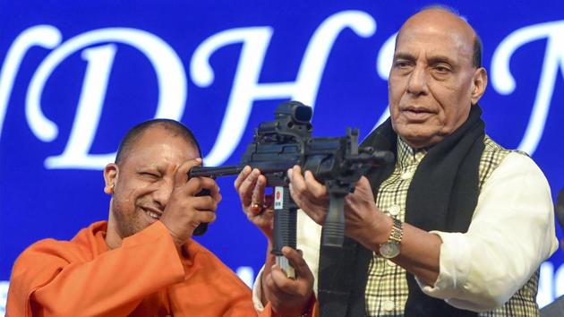 Uttar Pradesh Chief Minister Yogi Adityanath checks a gun held by Defence Minister Rajnath Singh at the 11th edition of DefExpo in Lucknow. (Nand Kumar / PTI)