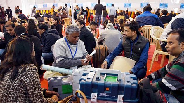 Polling officials checking the Electronic Voting Machine (EVMs) and other necessary inputs required for the Delhi Assembly Election, at a distribution centre, at Kamla Nehru College, in New Delhi on Friday. (ANI PHOTO) Polling officials checking the Electronic Voting Machine (EVMs) and other necessary inputs required for the Delhi Assembly Election, at a distribution centre, at Kamla Nehru College, in New Delhi on Friday. (ANI PHOTO)