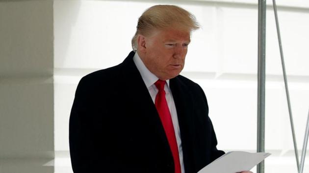 U.S. President Donald Trump holds a copy of a U.S. appeals court ruling as he departs for travel to North Carolina from the South Lawn of the White House in Washington.(REUTERS)