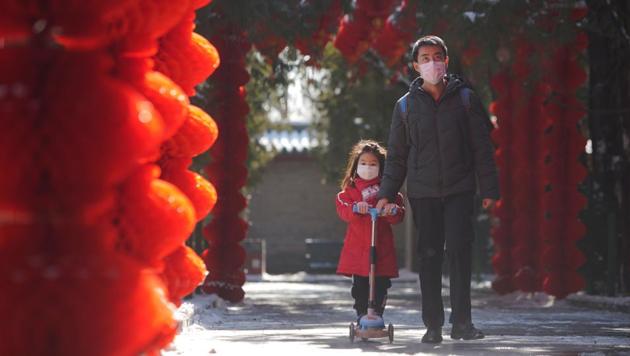 A man wearing a face mask walks with a girl past red lanterns at Ditan Park on the Lantern Festival, which marks the end of the Chinese Lunar New Year celebrations, in Beijing. (REUTERS) A man wearing a face mask walks with a girl past red lanterns at Ditan Park on the Lantern Festival, which marks the end of the Chinese Lunar New Year celebrations, in Beijing. (REUTERS)