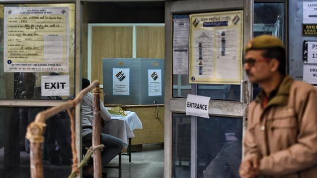 A security personnel stands outside the entry to a polling booth at Civil Lines. As many as 190 companies of the Central Armed Police Forces (CAPF) have been deployed for the smooth conduct of the election today. Besides this, 19,000 Home Guards and 42,000 Delhi Police personnel are also on duty. (Sanchit Khanna / HT Photo)