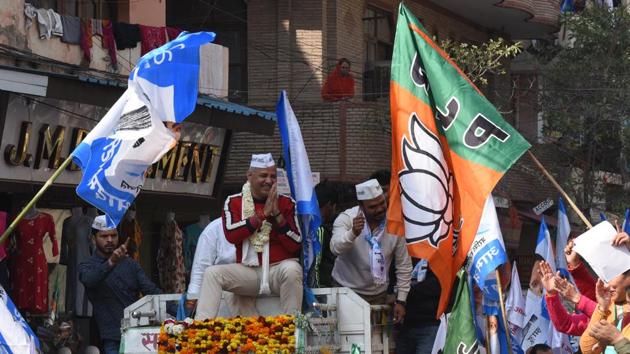 A BJP rally runs into Delhi Deputy CM and AAP candidate from Patparganj constituency Manish Sisodia while on an election campaign roadshow at Sabzi Mandi in New Delhi. (Sonu Mehta / HT Photo)