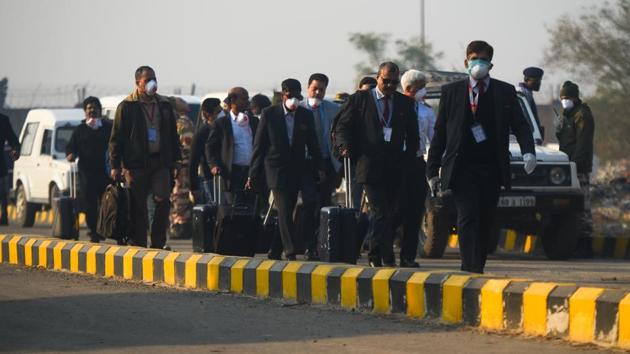 Crew members and officials of an Indian airline carry their belongings while wearing protective masks as a precaution against a possible coronavirus infection on their return from China, at IGI Airport. Researchers found out that in India, IGI Airport is most likely to get infected people, followed by airports Mumbai and Kolkata. (Amal KS / HT Photo)