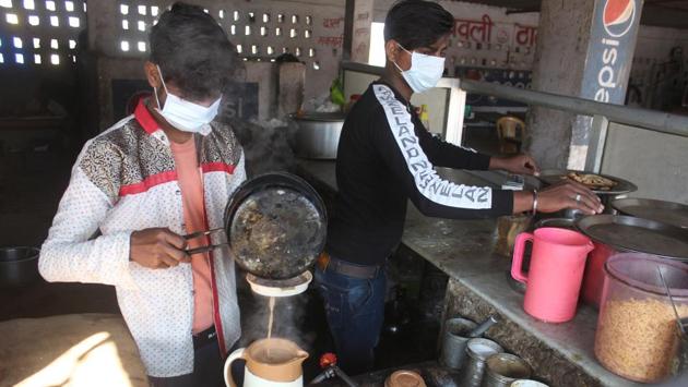 Boys are seen wearing masks while working at a dhaba right opposite the camp at Manesar. With reference to the students at Kochi, a senior health ministry official said, “They will be quarantined and tested just like any other persons travelling from China. They will be discharged if their tests come back negative.” (Yogendra Kumar / HT Photo)