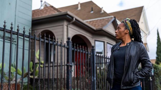 Dominique Walker surveys a vacant home in Oakland, California. When Walker moved back from Mississippi to her native California last year, she planned to pursue a nursing degree while caring for her children. But she and other moms and their children ended up living as squatters in a bold protest against homelessness. (Philip Pacheco / AFP)