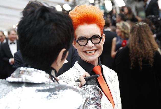 Diane Warren, left, signs Sandy Powell's blazer on the red carpet at the Oscars on Sunday, Feb. 9, 2020, at the Dolby Theatre in Los Angeles. (AP Photo/John Locher) (AP)
