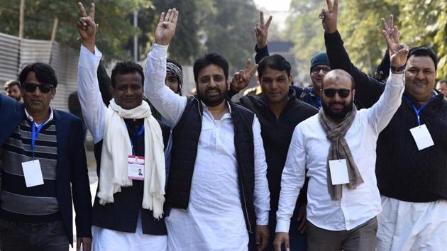 AAP candidate Amanatullah Khan from the Okhla assembly constituency displays the victory sign along with his supporters at the Maharani Bagh counting centre in New Delhi.(BURHAAN KINU/HT PHOTO.)