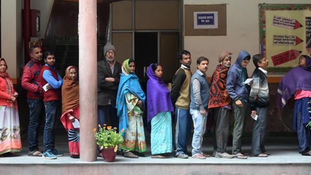 Voters stand in queues to cast their votes at a polling station, at St Giri Public School, Sarita Vihar, in New Delhi, India, on Saturday, February 8, 2020.(Amal KS/HT PHOTO)