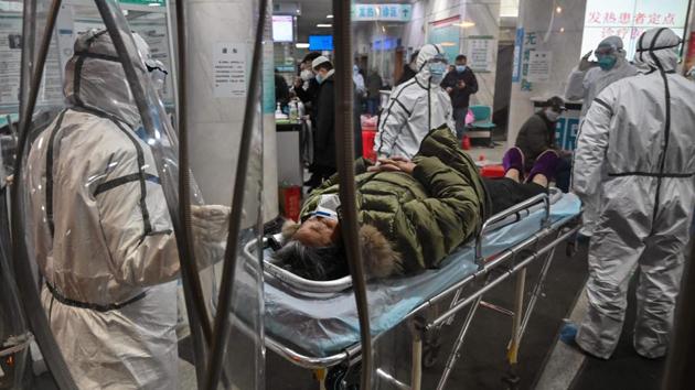 Medical staff in protective gear to help stop the spread of the deadly virus which began in the city as they arrive with a patient at the Wuhan Red Cross Hospital in Wuhan, on January 25, 2020. For eight days, beginning January 23, an AFP team lived and worked at the centre of a global health emergency, witnessing how life in the Chinese city was turned upside down as it was cut off from the world. (Hector Retamal / AFP)