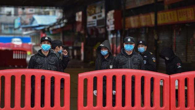 Police officers and security guards stand outside the Huanan Seafood Wholesale Market where coronavirus was first detected in Wuhan. People approached foreign journalists unprompted—a rare sight in China—to describe grim scenes in other hospitals. “Like a horror film,” said one witness, recalling how bodies were left unattended for hours. (Hector Retamal / AFP)