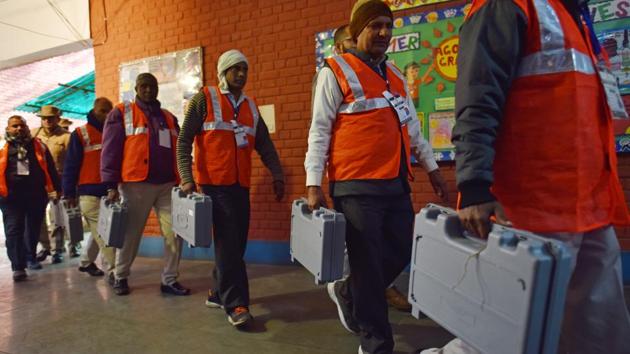 Polling officials seen carrying EVMs.(Sanchit Khanna/HT PHOTO)