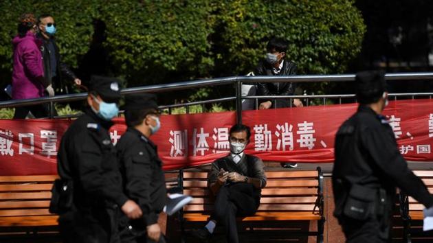 Police officers walk past a man holding his mobile phone while wearing face mask and plastic gloves, on a street following an outbreak of the novel coronavirus in the country, in Kunming, Yunnan province, China on February 13. (Reuters Photo) Police officers walk past a man holding his mobile phone while wearing face mask and plastic gloves, on a street following an outbreak of the novel coronavirus in the country, in Kunming, Yunnan province, China on February 13. (Reuters Photo)
