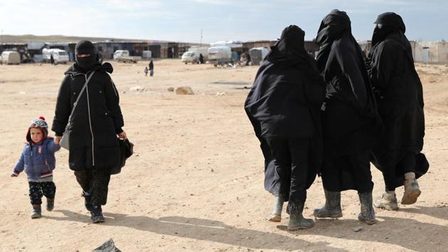 A woman holds hands with a child while walking through al-Hol camp. “I have one child and my husband died in Baghouz,” she said, flanked by her toddler son. The woman said she was in touch with her family in Hong Kong but did not want to return. “I know here the situation is very difficult. This is not home, it’s just a tent ... but we all live to (the wishes of) Allah, so God-willing, all is good.” (Goran Tomasevic / REUTERS)