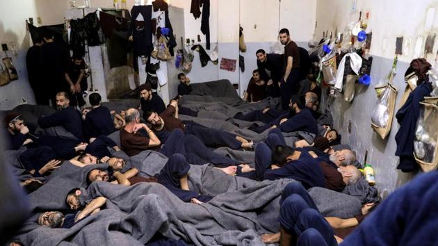 Foreign prisoners, suspected of being part of the Islamic State, in a prison cell in Hasaka, Syria. In the country’s northeast, prisons and detention camps hold thousands of men, women and children whose lives are in limbo nearly a year after the final defeat of Islamic State to which they once belonged. (Goran Tomasevic / REUTERS)