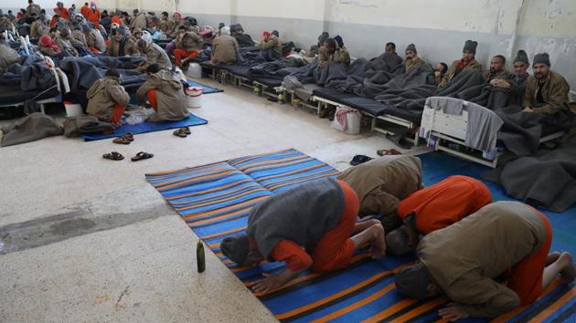 Foreign prisoners, suspected of being part of the Islamic State, pray inside a prison hospital in Hasaka. Kurdish officials say they lack the resources to properly detain, investigate and prosecute the large number of prisoners as well as their families in camps. They have called repeatedly on foreign nations to take back their citizens. (Goran Tomasevic / REUTERS)