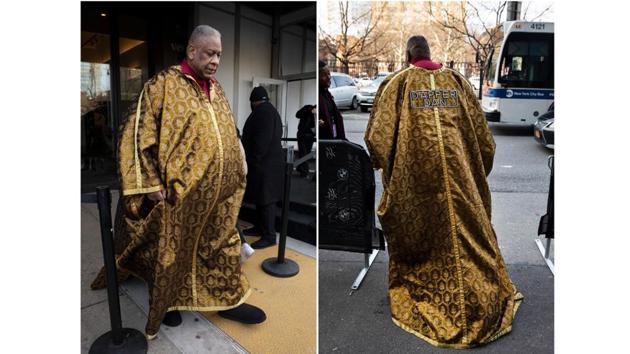 Fashion journalist Andre Leon Talley walks outside a show . He wears a cape with the name "Dapper Dan." The Harlem fashion legend snapped photos with fans dressed in a yellow print bow tie and matching scarf. Talley, of course, wore one of his signature caftans emblazoned on the back with “Dapper Dan” on the back. (Mark Lennihan / AP)