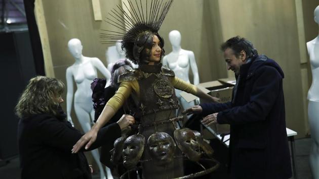 A model puts on a creation partially made of chocolate backstage before a fashion show during an annual chocolate festival in Brussels, Thursday, Feb. 13, 2020. (AP Photo/Francisco Seco) (AP)