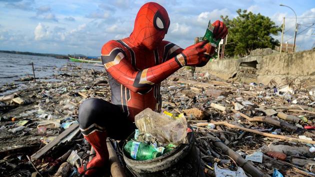 Rudi Hartono, a man dressed in Spiderman costume, looks at plastic waste as he collects rubbish at a beach in Pare-Pare, South Sulawesi province, Indonesia. (REUTERS)