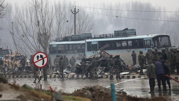 Security forces near the damaged vehicles at Lethpora after the Pulwama attack on the Jammu-Srinagar highway, Jammu and Kashmir on February 14, 2019.(Waseem Andrabi/HT Photo)