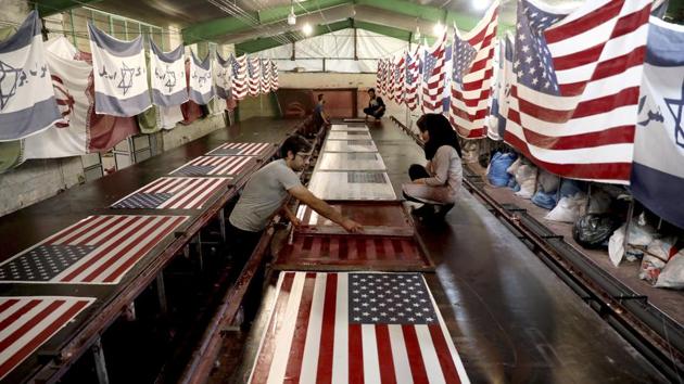 Workers print US flags using a silkscreen, at the Diba Parcham Khomein factory in Heshmatieh village, a suburb of Khomein city, in central Iran. This factory serves as a major producer for the American and Israeli flags constantly burned at demonstrations in the Islamic Republic. (Ebrahim Noroozi / AP)