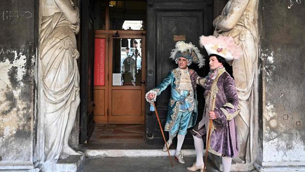 Masked revellers pose at St Mark Square during the opening of the Venice Carnival. (Vincenzo Pinto / AFP)