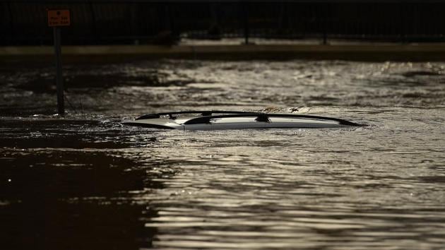 The roof of a submerged car is pictured in a flooded street in Mytholmroyd, northern England, after the River Calder burst its banks as Storm Ciara swept over the country. (Oli Scarff / AFP)