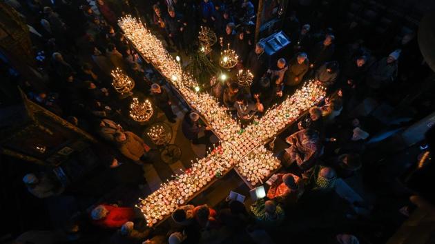Believers attend a ceremony marking the day of Saint Haralampi, protector of beekeepers, around a cross-shaped platform covered with candles placed in jars of honey, at the Church of the Blessed Virgin in Blagoevgrad, Bulgaria. (Nikolay Doychinov / AFP)