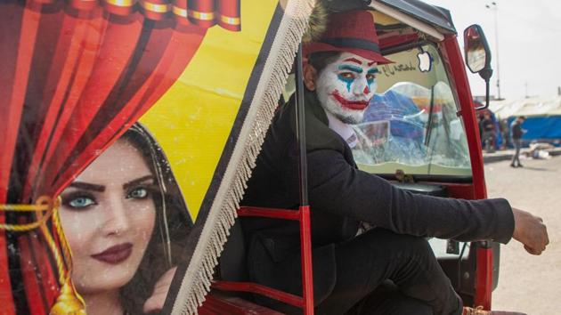 An Iraqi demonstrator dressed in a Joker outfit poses for a picture inside as he sits inside a Tuk-Tuk during an anti-government demonstration by Basra University students in the southern city of Basra, Iraq. (Hussein Faleh / AFP)
