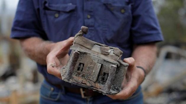 Farmer Jeff McCole, 70, displays a model house, made by his son Aaron, that remained after bushfire destroyed his family home in Buchan, Victoria, Australia. (Andrew Kelly / REUTERS)
