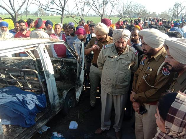 Police personnel inspect the damaged school van, after it caught fire in Sangrur district of Punjab on Saturday.(HT Photo)