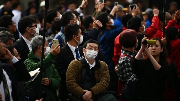 People wearing facemasks look on during a rehearsal of the Tokyo 2020 Olympics torch relay in Tokyo on February 15, 2020. (AFP file photo) People wearing facemasks look on during a rehearsal of the Tokyo 2020 Olympics torch relay in Tokyo on February 15, 2020. (AFP file photo)